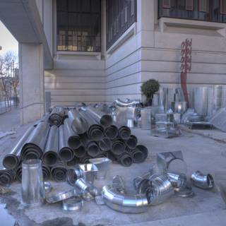 Pile of Metal Pipes on the Sidewalk