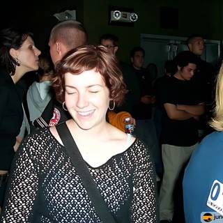 Smiling Woman Stands Out in Crowded Nightclub