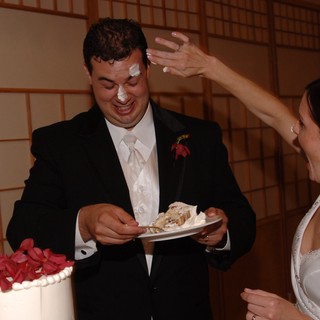 Playful Wedding Cake Smashing Moment at Reception