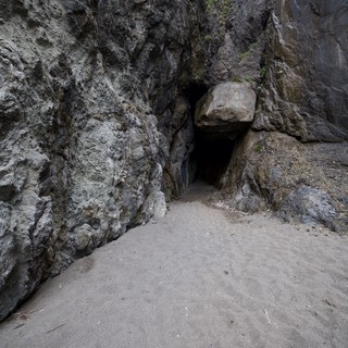 Dark Cave Entrance in Coastal Rock Cliffs