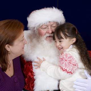 Santa Claus joins a mother-daughter duo on the couch