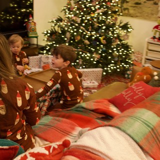Christmas Morning Family Gathering Around Illuminated Tree