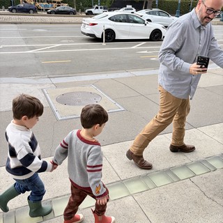 Father and Sons Walking Through Urban Sidewalk