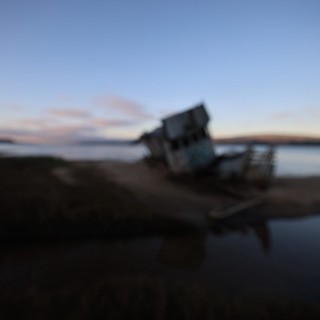 Shipwreck at Twilight on Coastal Beach
