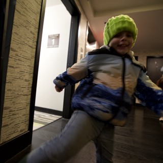 Young Child Running Through Modern Building Hallway