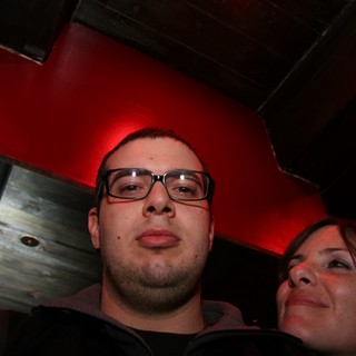 Low-Angle Nightclub Portrait Under Red Lighting