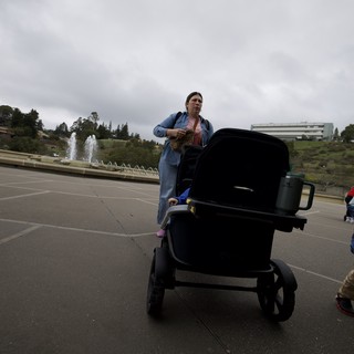 Woman with Baby Stroller in Cloudy Park Plaza