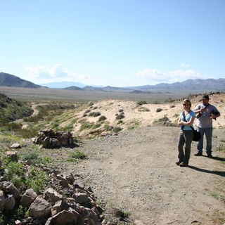Two Hikers Pause on Desert Trail with Mountain Vista