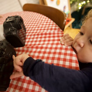 Curious Toddler Exploring Professional Camera Equipment