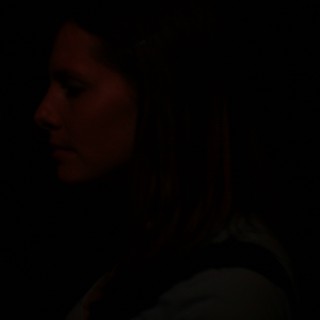 Silhouette in Darkness: Profile Bathed in Red Light