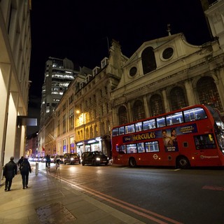 Red Double-Decker Bus on London Street at Night