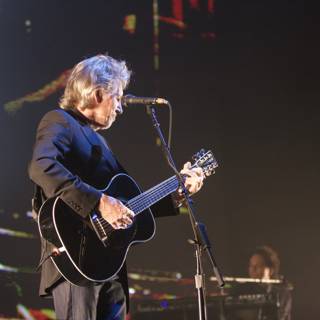 Strumming Solo: A Man with His Acoustic Guitar on Stage