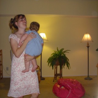 Joyful Mother Lifting Laughing Baby in Living Room