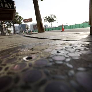 Manhole Cover on City Sidewalk