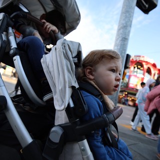 Young Child Watches Carnival Lights at Twilight Fair