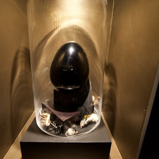 Black Egg Sculpture Under Glass Display
