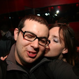 Spontaneous Kiss at a Dimly Lit Nightclub Party