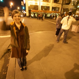 Smiling Woman Celebrates on City Street at Night