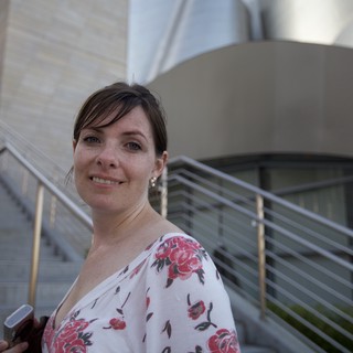 Woman Smiling Outside Modern Concert Hall Steps