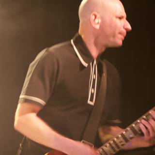 Bald Man Rocks the Electric Guitar on Stage