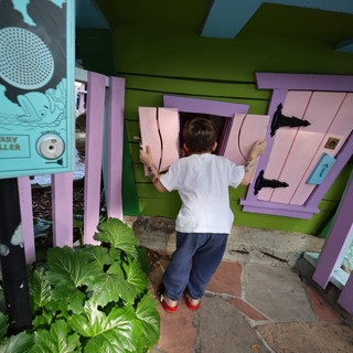 Child Playing at Colorful Miniature Playhouse