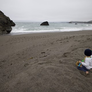 Solitary Child Playing on Dramatic Pacific Coastline