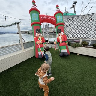 Children Enjoying Inflatable Christmas Display by the Water