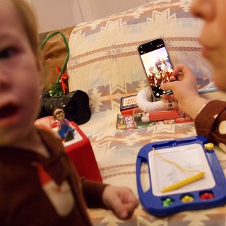 Christmas Day Playtime: Child Capturing Holiday Toys on Phone