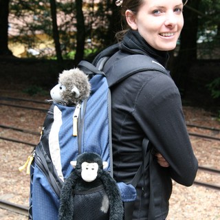 Smiling Woman with Stuffed Monkey Backpack Companions
