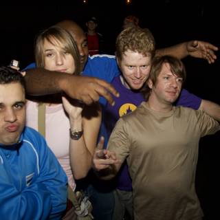 Group of Three Men with Colorful T-Shirts Posing for Picture at Night Club