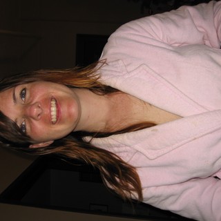 Smiling Woman in Pink Robe Holding Camera