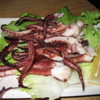 Octopus on a Plate with Lettuce and Lemon