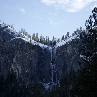 Snowy Waterfall Cascading Down Dark Granite Cliffs