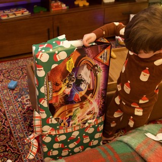 Child Unwrapping Wolverines Toy on Christmas Morning