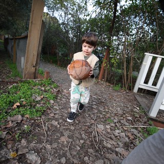 Young Child Playing with Basketball in Garden Path