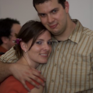 Couple Embracing Warmly at an Indoor Gathering