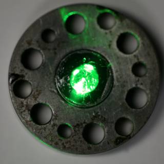 Glowing Emerald Gemstone on Metal Plate