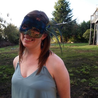 Smiling Woman in Peacock Feather Masquerade Mask