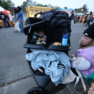 Tired Toddler in Stroller at Outdoor Festival