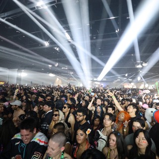 Massive Indoor Rave Crowd Bathed in Spectacular Light Beams