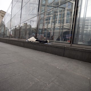 Homeless Person Sleeping Outside Modern Glass Building