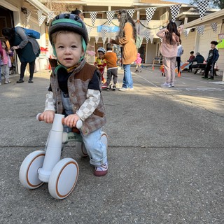 Young Child on Balance Bike at Neighborhood Block Party