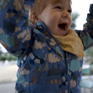 Joyful Toddler in Cloud-Pattern Winter Jacket