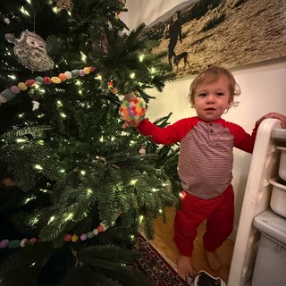Toddler Decorating Christmas Tree in Festive Pajamas