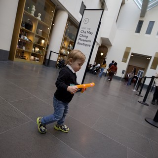 Young Child Exploring Asian Art Museum with Toy