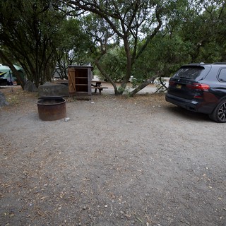 BMW SUV Parked at Shaded Campground Fire Pit