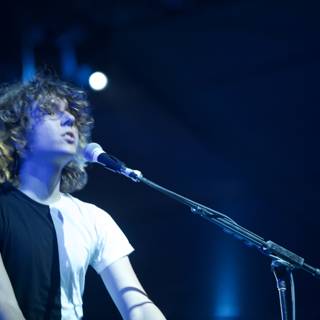 Man with curly hair rocks the stage