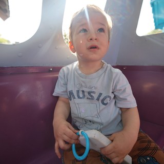 Young Child Gazing Upward on Amusement Park Ride