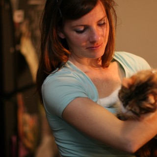 Woman Tenderly Cradling a Fluffy Tabby Cat