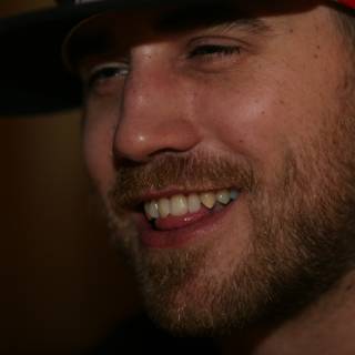 Smiling Bearded Man in Red Hat